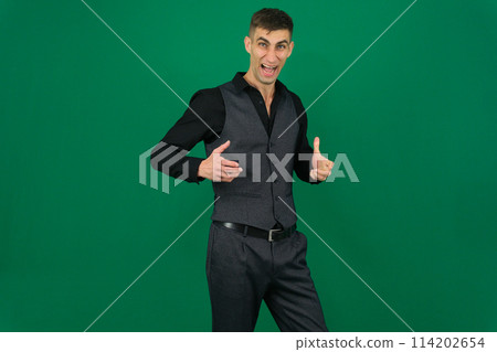 Handsome man doing different expressions in different sets of clothes emotions of a handsome man guy on a green background chromakey close-up dark hair young man 114202654