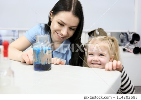 jar with blue bubbles Little scientist. Curious daughter play with mom engaged at education activity make funny experiment. Interested small girl watch elder sister doing chemical test use chemistry jar with blue bubbles Little scientist. Curious daughter play with mom engaged at education activity make funny experiment. Interested small girl watch elder sister doing chemical test use chemistry 114202685
