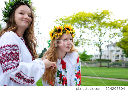 ancient traditions girls dress up before party young women want to look beautiful Ukrainian evening parties look smile braid hair wear beautiful embroidered shirts in the Peacetime of Ukraine 114202804