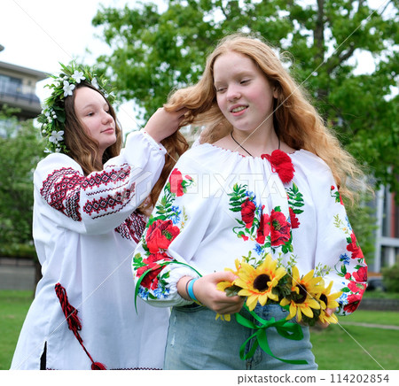 envy looking at the beauty of others the girl straightens the wreath to her friend wants the same embroidered shirt for herself preparing for a party for her friend envy looking at the beauty of others the girl straightens the wreath to her friend wants the same embroidered shirt for herself preparing for a party for her friend 114202854
