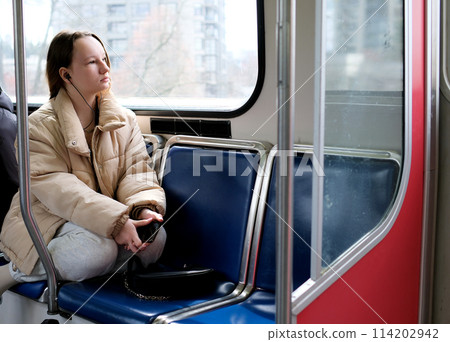 young girl teenager rides in transport looks out the window flashing houses close-up calm peaceful face space for text Sky Train bus car ordinary person in real life street Cities vancouver suburb 114202942