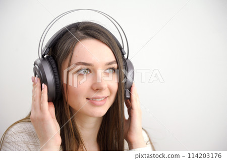Happy woman dreaming listening music with phone headphone on white 114203176