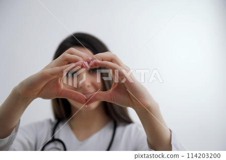 Close up of two female caucasian hands isolated on white background. Young woman forming shape of heart with her fingers. Horizontal color photography. Point of view shot 114203200