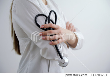 Closeup portrait of a female doctor holding her stethoscope on white background Closeup portrait of a female doctor holding her stethoscope on white background 114203201