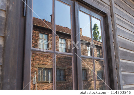 [Poland] A brick building reflected in the window of a wooden building in the Auschwitz-Birkenau concentration camp 114203846