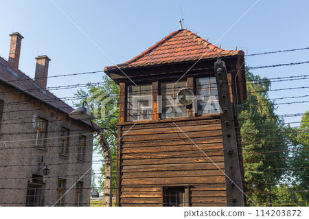 [Poland] A guard tower seen through the barbed wire fence at Auschwitz-Birkenau concentration camp 114203872