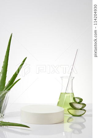 Empty pedestal placed in the middle of white background photo, decorated with aloe vera, an erlenmeyer with light green fluid and a glass contains aloe vera. Blank space for displaying product Empty pedestal placed in the middle of white background photo, decorated with aloe vera, an erlenmeyer with light green fluid and a glass contains aloe vera. Blank space for displaying product 114204930