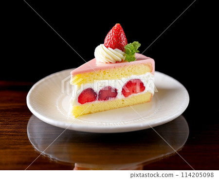 A slice of strawberry shortcake on a plate on a black background A slice of strawberry shortcake on a plate on a black background 114205098
