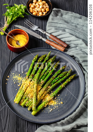 roasted asparagus with nut yeast crumble on plate roasted asparagus with nut yeast crumble on plate 114206108