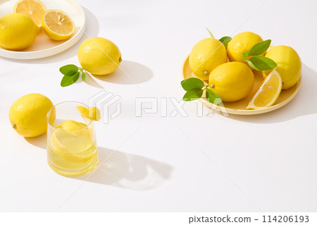 White table containing some round dishes of lemon, a glass of lemon juice and some lemons flat lay above. Top view photo with blank space for text White table containing some round dishes of lemon, a glass of lemon juice and some lemons flat lay above. Top view photo with blank space for text 114206193