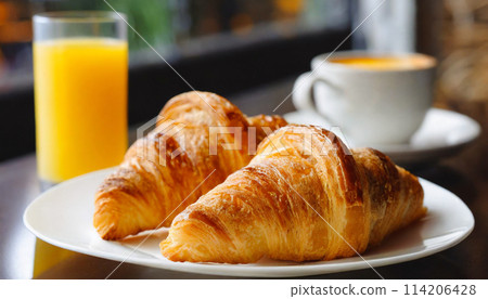 早餐桌附有新鮮出爐的羊角麵包和柳橙汁 114206428