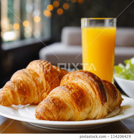 早餐桌附有新鮮出爐的羊角麵包和柳橙汁 114206429
