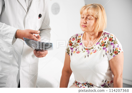 Patient making MRI, doctor holding and explaining results. Woman sitting on couch. Concept of medicine and healthcare. 114207368