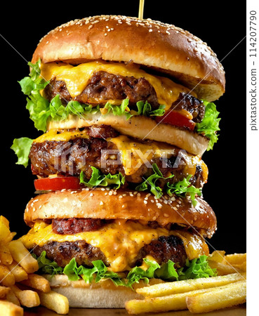 A cheese burger as voluminous as a tower on a black background 114207790