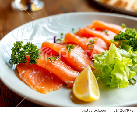 Smoked salmon and lemon on a white plate 114207972
