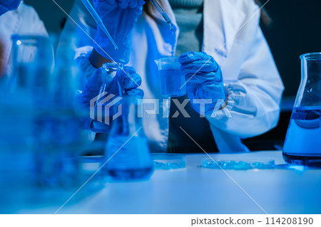 Medical or research scientist or doctor using looking at a test tube of clear solution in a lab or laboratory. 114208190