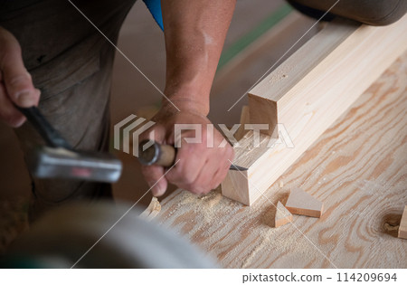 Carpenter working with a chisel Carpenter working with a chisel 114209694