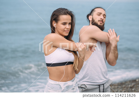 Couple stretching on beach 114211626