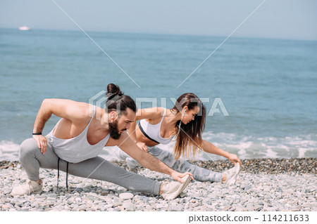Stretching before everyday jogging on the beach 114211633