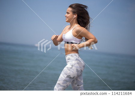 Woman training yoga on the beach at sunset 114211684