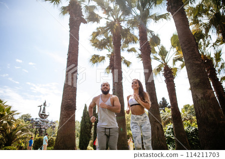 Young couple running in park in summer morning Young couple running in park in summer morning 114211703