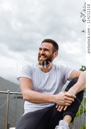 Handsome muscular hunk man looking at mountains from the peak. Handsome muscular hunk man looking at mountains from the peak. 114212318