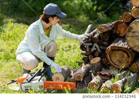 Woman cutting firewood 114212348