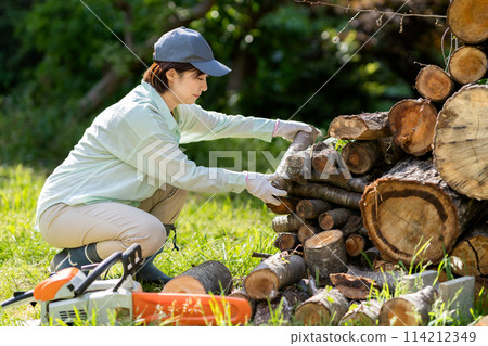 Woman cutting firewood 114212349