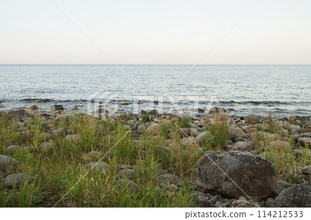 Summer evening on a lake shore with big stones Summer evening on a lake shore with big stones 114212533