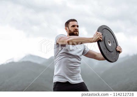 Handsome muscular hunk man looking at mountains from the peak. Handsome muscular hunk man looking at mountains from the peak. 114212728