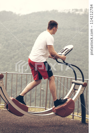 Man performs sport exercise, fitness street workout. Healthy Lifestyle. Man performs sport exercise, fitness street workout. Healthy Lifestyle. 114212784
