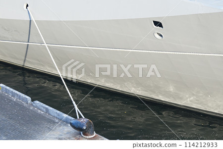 A ship moored with ropes to a quay 114212933