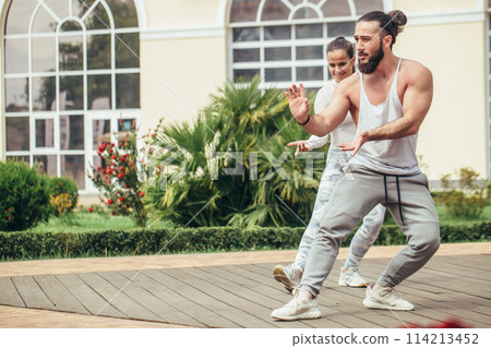 Karate group making shot show-performance on a squre before fitness centre 114213452