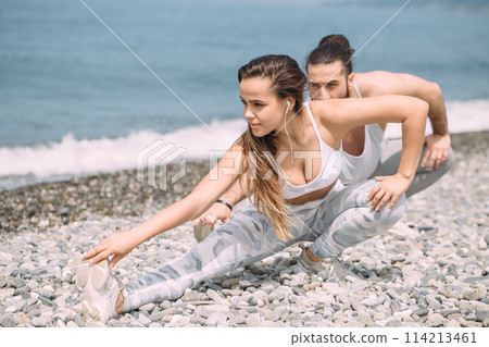 Stretching before everyday jogging on the beach 114213461