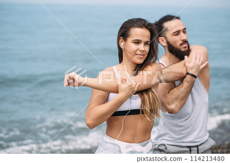 Couple stretching on beach Couple stretching on beach 114213480
