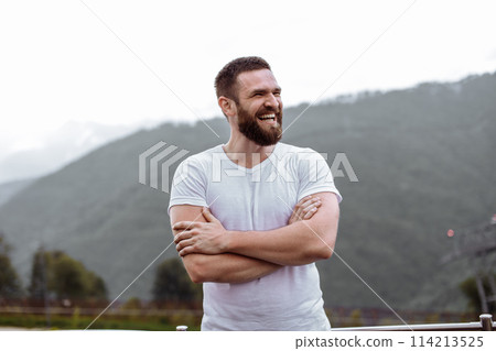 Handsome muscular hunk man looking at mountains from the peak. Handsome muscular hunk man looking at mountains from the peak. 114213525
