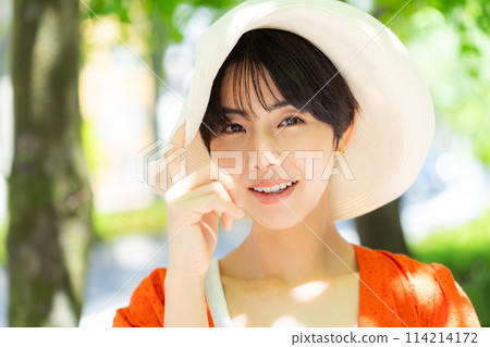 A woman wearing a straw hat 114214172