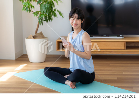 Woman doing yoga in the living room 114214201