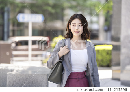 A businesswoman in her 30s walking through an office district A businesswoman in her 30s walking through an office district 114215296