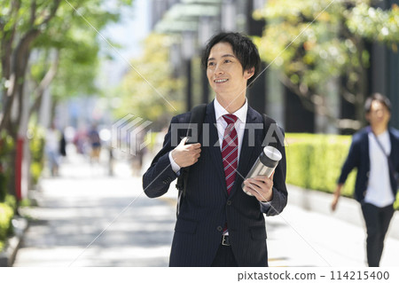 一個30多歲的商人帶著自己的瓶子走路 114215400