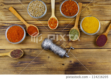 Set of different aromatic spices and spice mill on wooden table. Top view 114216205