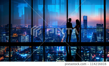 Business professionals shaking hands against city skyline backdrop from highrise office at twilight 114216816