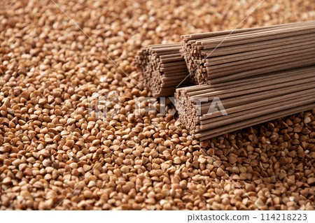 Raw buckwheat noodles soba on grain. Space for text. Healthy vegan diet. Close up. Alternative gluten free pasta. Raw buckwheat noodles soba on grain. Space for text. Healthy vegan diet. Close up. Alternative gluten free pasta. 114218223