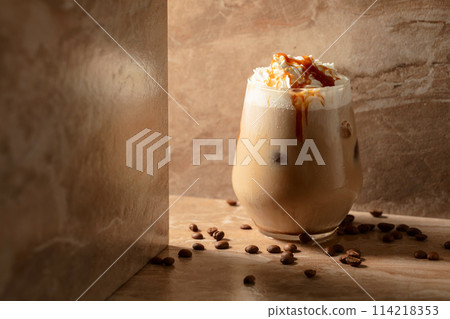 Iced caramel latte topped with whipped cream and caramel sauce. Iced caramel latte topped with whipped cream and caramel sauce. 114218353