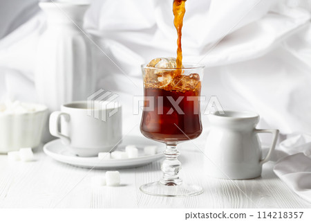 Iced coffee, cup of black coffee and sugar on a white wooden table. 114218357