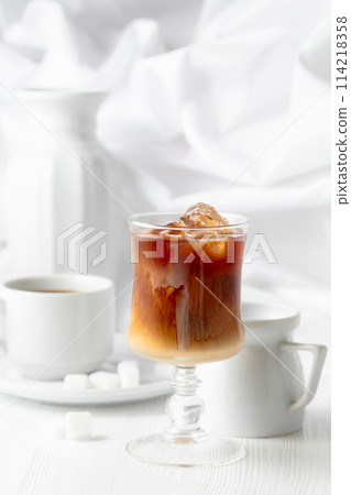 Iced coffee with cream and cup of black coffee. 114218358