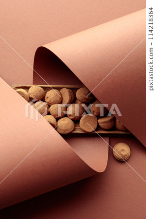 Tasty chocolate truffles in a wooden dish on a brown background. Tasty chocolate truffles in a wooden dish on a brown background. 114218364