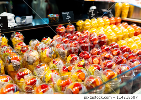 Fruit Salad arranged in plastic cups on a market. Cut and ready fruit ready to sell in market. Convenience, healthy lifestyle. Strawberries, kiwi, melon, pineapple, figs, dragon in a plastic glass. Fruit Salad arranged in plastic cups on a market. Cut and ready fruit ready to sell in market. Convenience, healthy lifestyle. Strawberries, kiwi, melon, pineapple, figs, dragon in a plastic glass. 114218597
