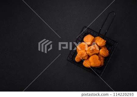Delicious fresh crispy chicken nuggets on a dark concrete background Delicious fresh crispy chicken nuggets on a dark concrete background 114220293