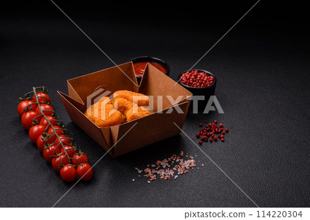 Delicious fresh crispy chicken nuggets on a dark concrete background 114220304